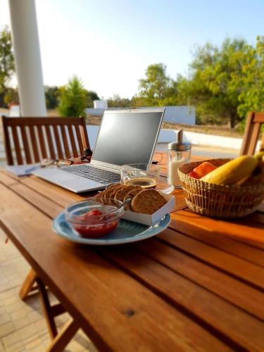 a laptop computer sitting on a table with a plate of food at Casa do Campo in Carvoeiro