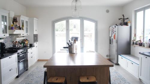 a kitchen with white cabinets and a wooden island in the middle at Villa San Martino in Cellino Attanasio