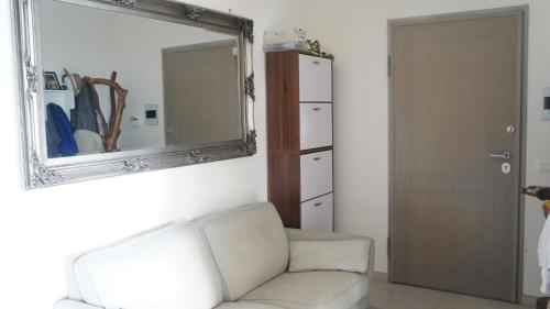 a living room with a white couch and a mirror at Villa San Martino in Cellino Attanasio