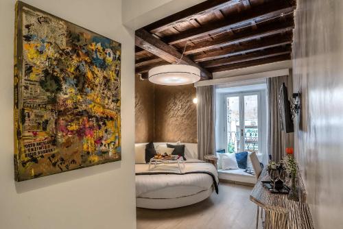 a bedroom with a large painting on the wall at Spagna Luxury'n Trevi in Rome