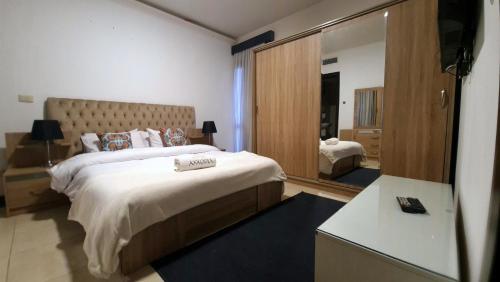 a bedroom with a large bed and a mirror at Axxodia- Duplex Porto New Cairo in Cairo
