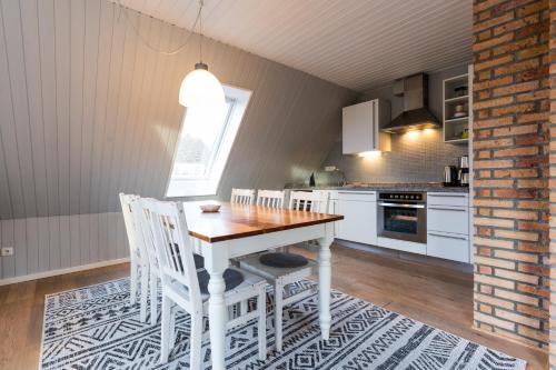 a kitchen with a table and chairs in a room at Inselhaus EG und OG in Staberdorf