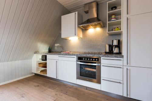 a kitchen with white cabinets and an oven at Inselhaus EG und OG in Staberdorf
