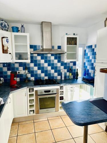 - une cuisine avec du carrelage bleu et blanc sur le mur dans l'établissement Charming village house, à Cambia