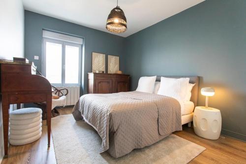 ein Schlafzimmer mit einem Bett und einem Klavier darin in der Unterkunft Appartement historique Dior in Granville