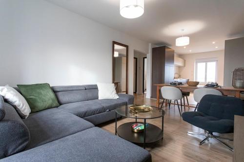 ein Wohnzimmer mit einem blauen Sofa und einem Tisch in der Unterkunft Appartement historique Dior in Granville