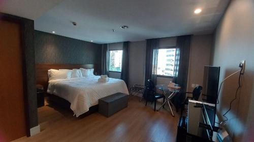 a hotel room with a bed and a television at Flat Hotel Executivo Ibirapuera Moema (Apto 844B) in Sao Paulo