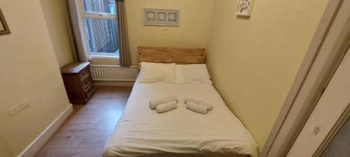 une petite chambre avec un lit avec deux oreillers dans l'établissement 4 Bedroom Apartment & 2 Bedroom apartment, à Londres