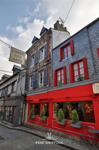 un bâtiment rouge sur le côté d'une rue dans l'établissement Emeraude Cozy Nest 3 Heart of Historic District 2 guests, à Honfleur