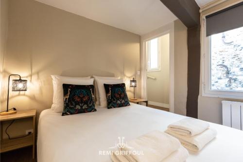 une chambre avec un lit blanc avec des oreillers et une fenêtre dans l'établissement Emeraude Cozy Nest 3 Heart of Historic District 2 guests, à Honfleur