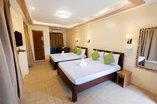 a hotel room with two beds and a television at Anahaw Seaside Inn in Bantayan Island
