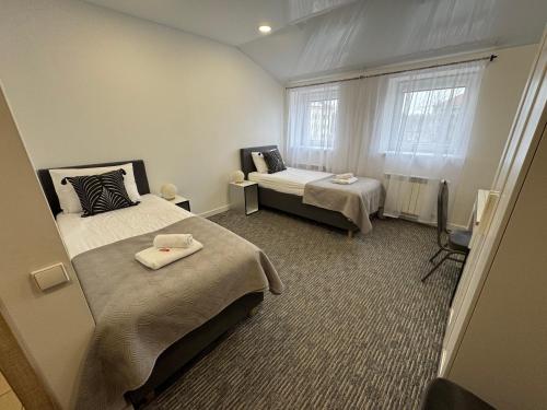a small room with two beds and a window at Grey apartments "Easy Kaunas" in Kaunas