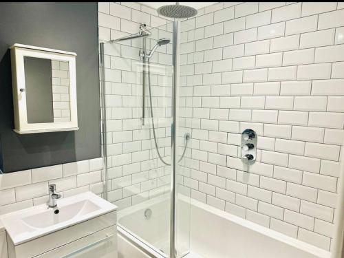 a white bathroom with a shower and a sink at Twist of Tranquility in Rochester in Rochester