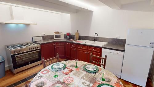 a kitchen with a table and a white refrigerator at Les appartements hyper centre Barr in Barr