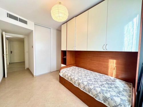 - une chambre avec un lit doté d'une tête de lit en bois et de placards dans l'établissement Very bright T2 near beach, à Cannes