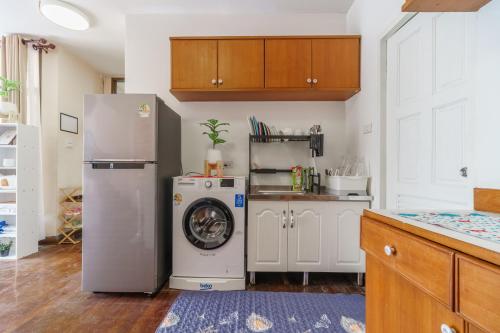 a kitchen with a refrigerator and a washing machine at Charming 3-Storey house near BTS Onnut Station in Bangkok