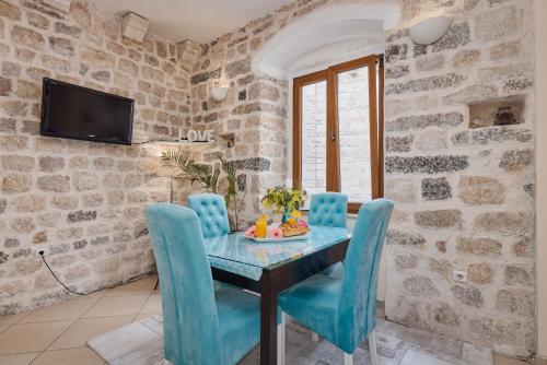 a dining room with a table and blue chairs at La Dolce Vita Apartment in Kotor