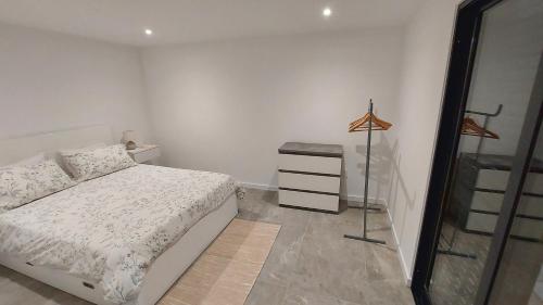 a bedroom with a bed and a dresser in it at Estúdio Laura in Câmara de Lobos
