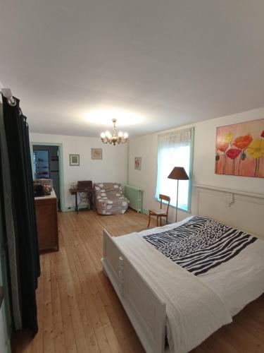 une chambre avec un grand lit et un salon dans l'établissement Gîte moderne à la campagne, à La Couture