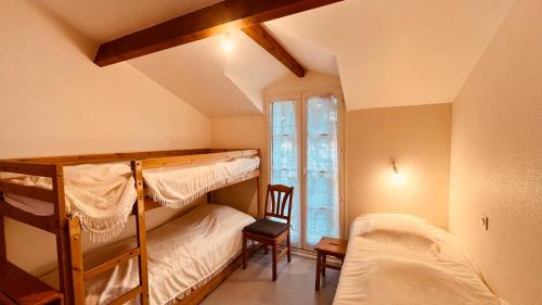 two bunk beds in a room with a window at Maison forêt et piscine, les Mas de Vertmarines in Saint-Jean-de-Monts