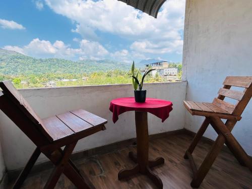 two chairs and a table with a potted plant on a balcony at Weligama Resort in Badulla
