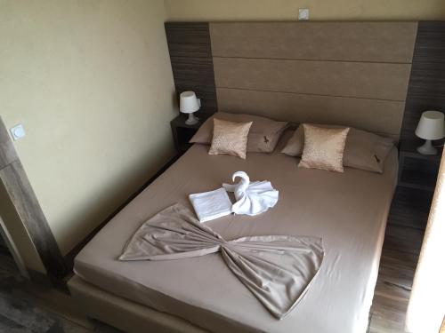 a bedroom with a bed with towels on it at Guesthouse Liamra in Ulcinj