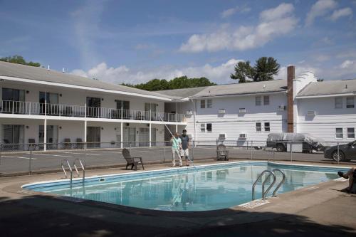 a couple of people standing next to a swimming pool at Lake George Residence LLC in South Glens Falls