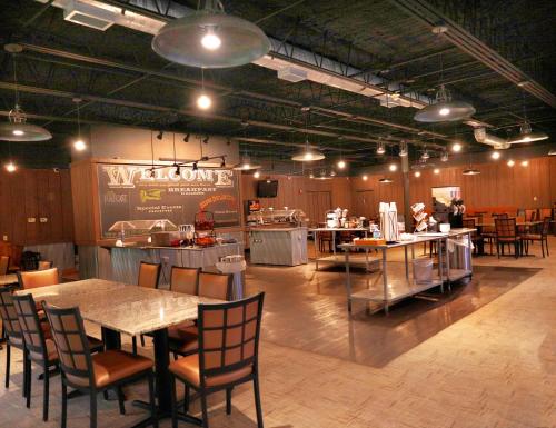 a restaurant with a table and chairs and a kitchen at Best Western Branson Inn and Conference Center in Branson