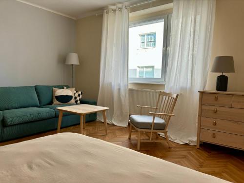 a bedroom with a couch and a table and a chair at Śląska 33 in Gdynia