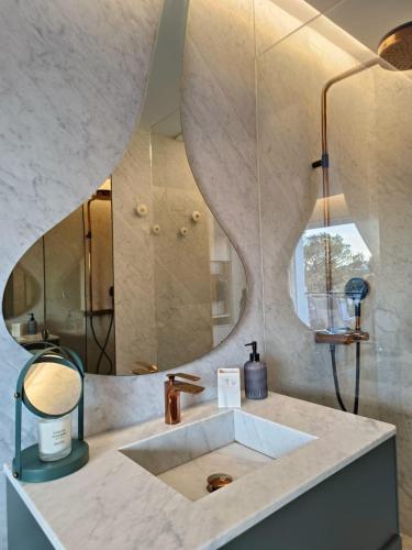 une salle de bain avec un lavabo et un miroir dans l'établissement L'écrin d'Azur appartement 5 personnes à 5 minutes à pied de la mer, à Saint-Raphaël