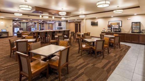 a restaurant with tables and chairs and a bar at Best Western Plus Lincoln Inn & Suites in Lincoln