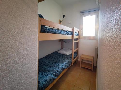 une chambre avec trois lits superposés dans une pièce dans l'établissement T2 cabine 4 personnes proche plage avec parking Le Lavandou - FR-1-803-61, au Lavandou