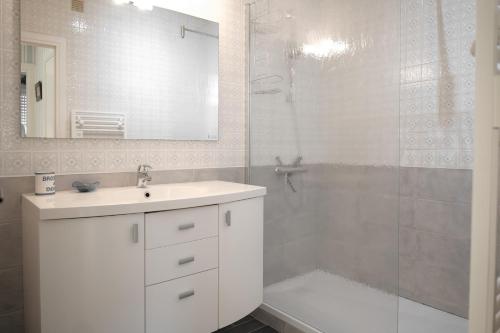 une salle de bain blanche avec un lavabo et une douche dans l'établissement Appartement avec vue imprenable sur la baie des Sables d'Olonne et le chenal - 4 personnes, à Les Sables-dʼOlonne