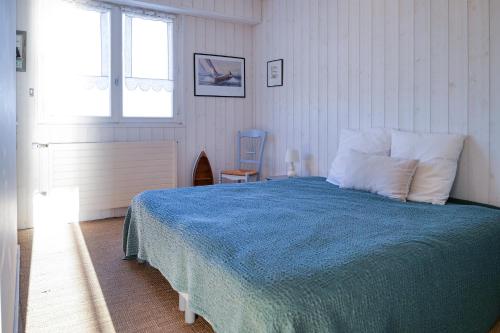 une chambre avec un lit, une fenêtre et une chaise dans l'établissement Appartement avec vue imprenable sur la baie des Sables d'Olonne et le chenal - 4 personnes, à Les Sables-dʼOlonne