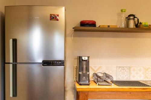 a stainless steel refrigerator in a kitchen next to a counter at Pousada K in Pirenópolis