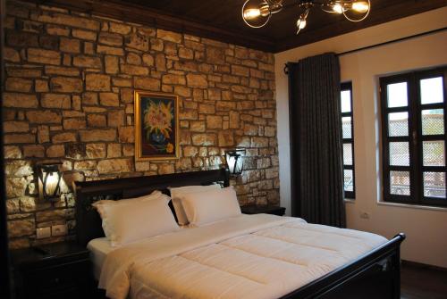 a bedroom with a large bed in a stone wall at White House Boutique Hotel & Restaurant - since 1999 in Berat