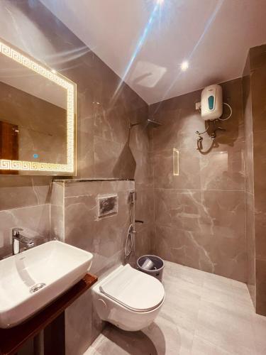 a bathroom with a toilet and a sink and a mirror at SHRI ANANDAM Inn in Isauli