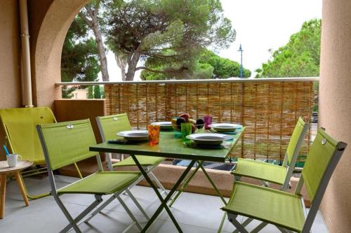 d'un balcon avec une table et des chaises vertes. dans l'établissement Appartement rénové Port de Hyères plage à pieds, à Hyères