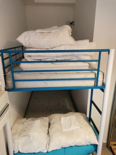 un groupe de serviettes blanches sur une étagère bleue dans l'établissement Appartement rénové Port de Hyères plage à pieds, à Hyères