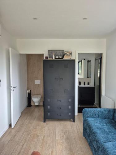 - un salon avec un canapé bleu et une commode dans l'établissement Chambre avec accès privé, à Saint-Saturnin