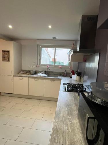 une cuisine avec un évier et une cuisinière four supérieur dans l'établissement appartement entier quartier calme, à Saint-Michel
