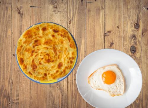 a bowl of food with an egg on a table at Republika Central Hotel & Resort in Abbottābād