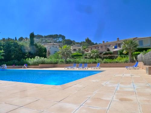une piscine avec des chaises et une maison en arrière-plan dans l'établissement Holiday Sun Villa, à Villeneuve-Loubet