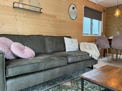 a living room with a couch with pillows on it at Cozy wooden cottage de Veluwe in Putten
