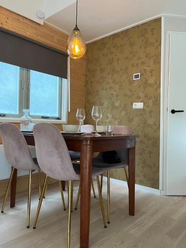 a dining room with a wooden table and chairs at Cozy wooden cottage de Veluwe in Putten