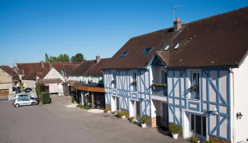 a row of blue and white buildings on a street at Logis Aux Maisons in Maisons-lès-Chaource