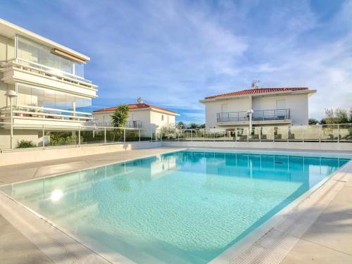 une grande piscine devant un immeuble dans l'établissement Le Royal Rivage - Piscine - À 200m de la mer, à Carqueiranne