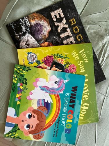 two childrens books sitting on a bed at 2BR Modern Home - Near WVU, Hospitals & Stadium in Morgantown