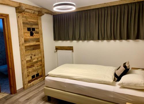 a bedroom with a bed and a window at Hotel Genziana in Arabba
