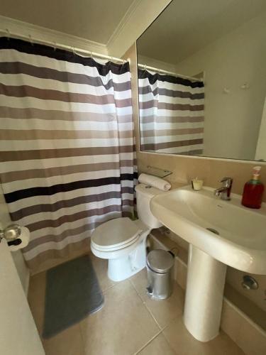 a bathroom with a toilet and a sink and a mirror at Departamento doña Bernardita in Arica